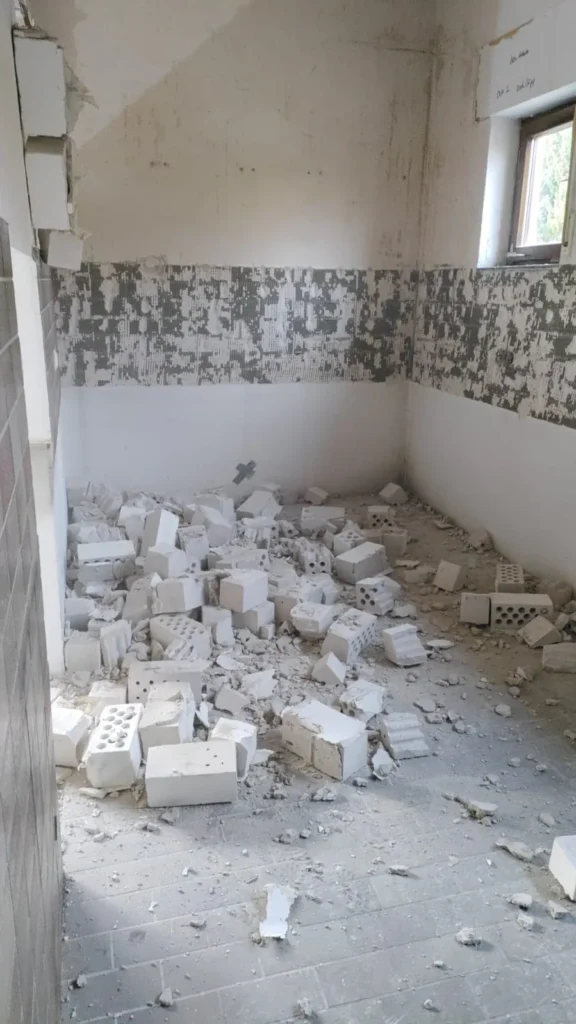 Das Bild zeigt Bauschutt, Mauersteine aus Kalksandstein, die in einem Raum liegen.