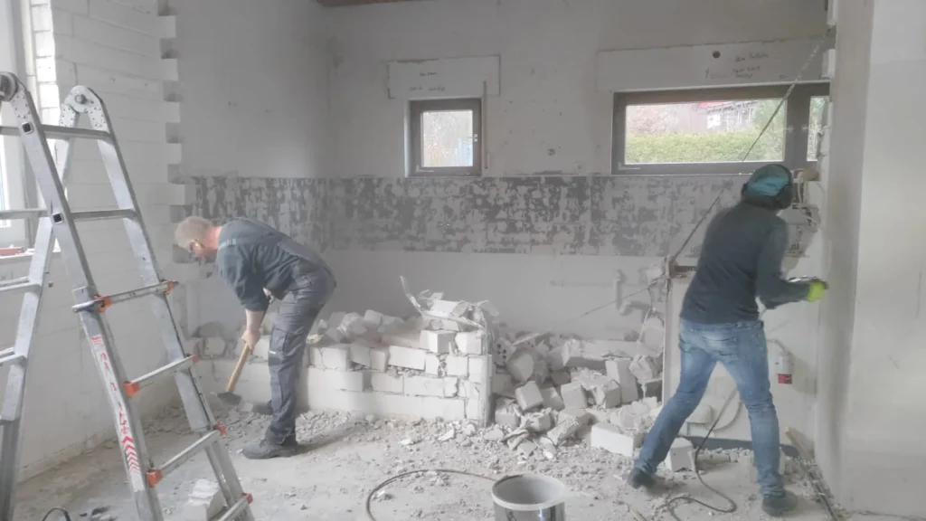 Das Bild zeigt zwei Personen bei Abbrucharbeiten im Missionsheim